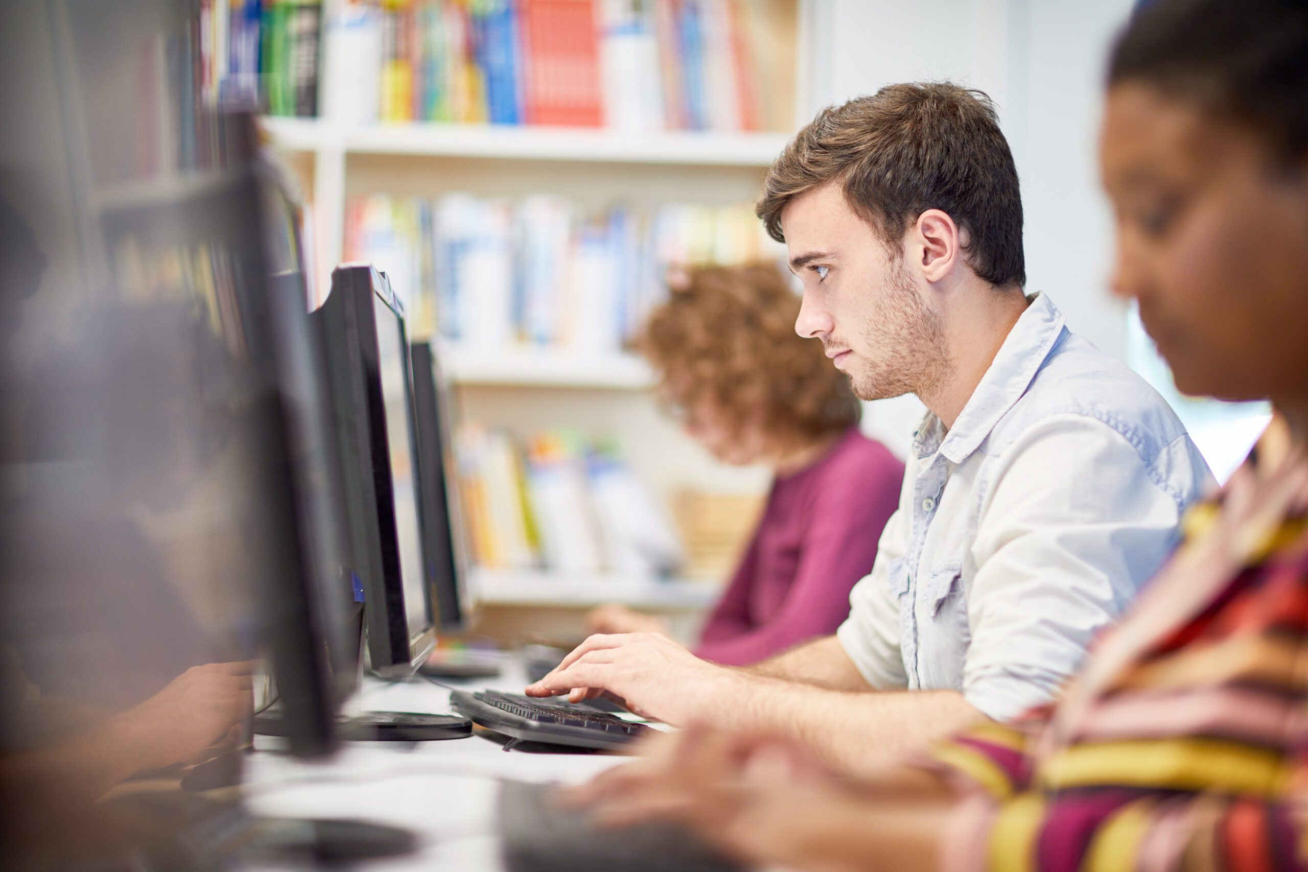 Concentrated young man working on computer at university